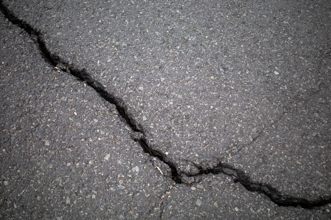 Fissure profonde dans une surface d’asphalte